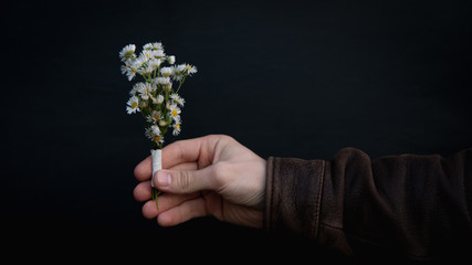 the guy is holding a small flower