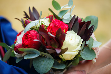 Beautiful wedding bouquet of flowers in the hands of the newlyweds