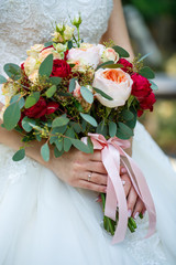 Beautiful wedding bouquet of flowers in the hands of the newlyweds