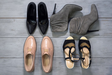 Various footwear on a wooden floor background.