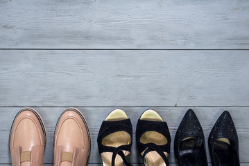 Various footwear on a wooden floor background with copy space.