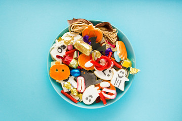 Halloween Jack o Lantern candy bowl with candy and halloween cookies Trick or Treat on blue background 