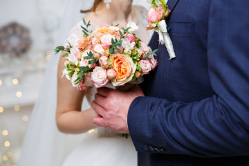 Beautiful wedding bouquet of flowers in the hands of the newlyweds