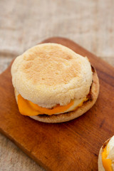 Homemade egg sandwich with cheese on a rustic wooden board, side view. Close-up.