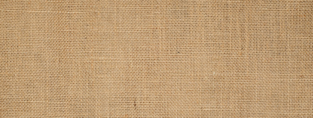Fototapeta na wymiar Cotton woven fabric background with flecks of varying colors of beige and brown. with copy space. office desk concept / Hessian sackcloth burlap woven texture background