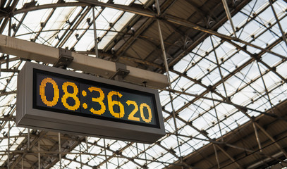 Yellowish digital clock with old classic style at the train station.