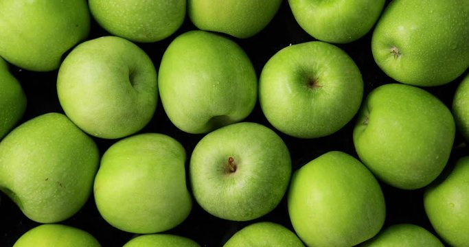 Green apples on black background, slow zoom in