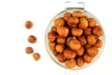 Hazelnuts in a jar on a white background