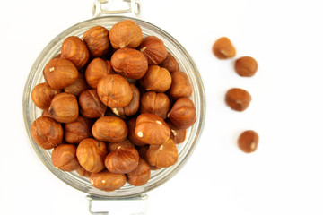 Orzechy laskowe w słoiku na białym tle