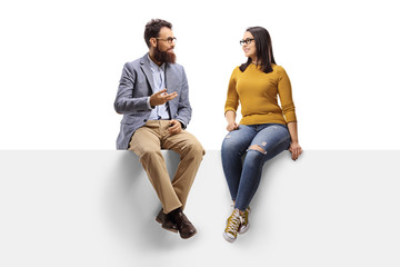 Fototapeta Bearded man talking to a young female seated on a banner obraz