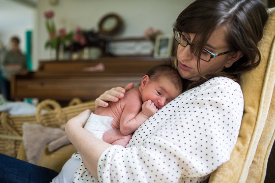 Mother holding newborn baby in nursery