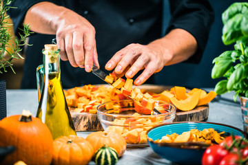 Chefkoch schneiden frische und leckere Hokkaido Kürbise  zum Kochen von Suppe