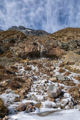 Andes mountains inside central Chile an amazing rugged landscape with steep rock faces and an awe scenery with a frozen river icefall and snowcapped mountains inside a wild environment