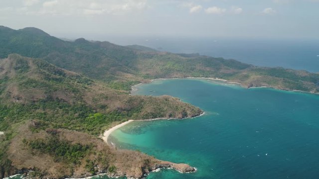 Aerial view coastline with tropical beach, island Limbones, lagoons and coral reefs. Neela cove, Philippines, Luzon. Coast ocean with turquoise water. Tropical landscape in Asia.