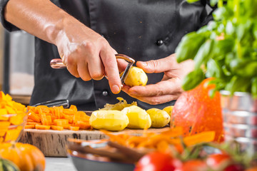 Chefkoch schält kartoffeln für ein Restaurant gericht
