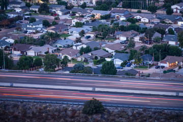 Predawn view of suburban homes and commuter freeway traffic near Los Angeles in Simi Valley, California.