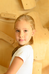 portrait of a cute little girl on a wooden background, close up