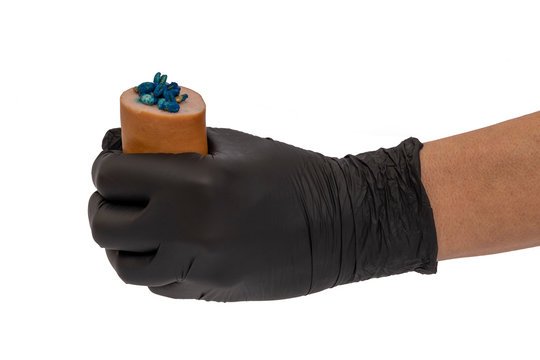 Wurst mit Giftk&ouml;der in einer Hand mit schwarzem Latexhandschuh