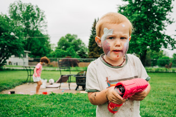 Boy playing outside with face covered in chalk