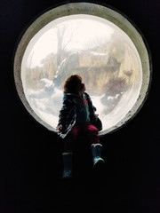 Girl looking out big window