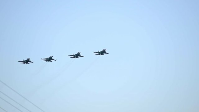 Column of four military warplanes flies over the ground. Military helicopters and planes in the evening sky. Air force parade. Independence Day parade in the CIS country. Belarus 3 July 2019.