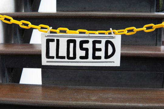 A closed sign on a yellow chain. Private area warned off from entering.