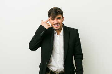 Young business hispanic man showing a disappointment gesture with forefinger.