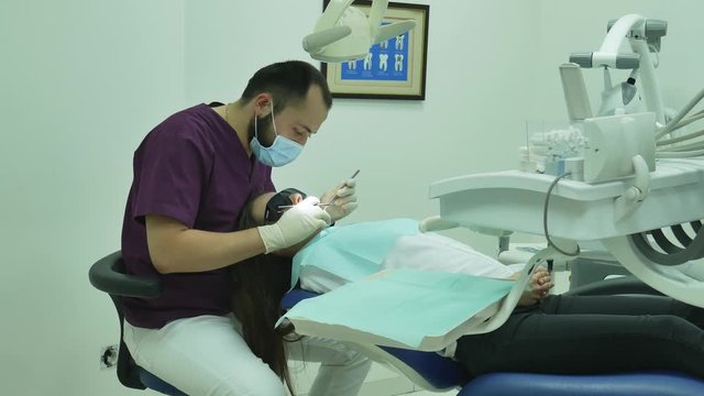 dentist examines a woman patient  medical clinic dental equipment