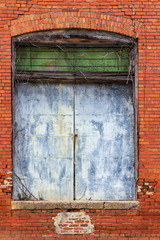A rusty metal door to an antique building.