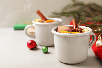 Cups of tasty mulled wine on grey table. Space for text