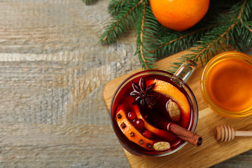 Glass cup of tasty mulled wine on wooden background, flat lay. Space for text