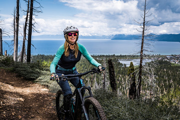 female mountain biker with lake and clouds