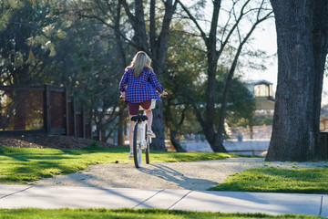female on cruiser bike in park