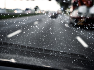 Driver POV of car driving on rainy highway with rain drops from a storm