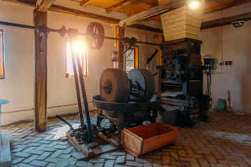 Old oil mill, millstones and and mechanical press - obrazy, fototapety, plakaty