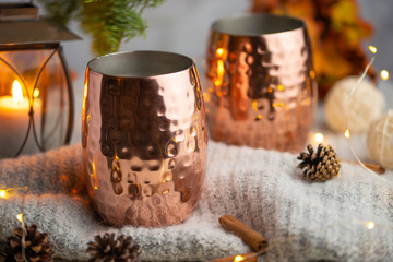 A cup of hot chocolate or tea and coffee on a warm wool blanket, with a Christmas background and atmosphere