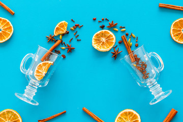 New Year beverage. Ingredients for mulled wine in glasses on blue background top view space for text mockup