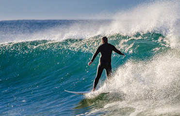 Surfer riding along on a small wave