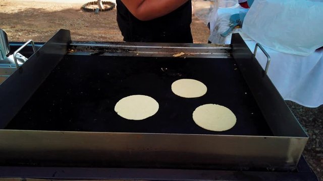 Chef for street food stand cooking soft shell tacos on outside grill