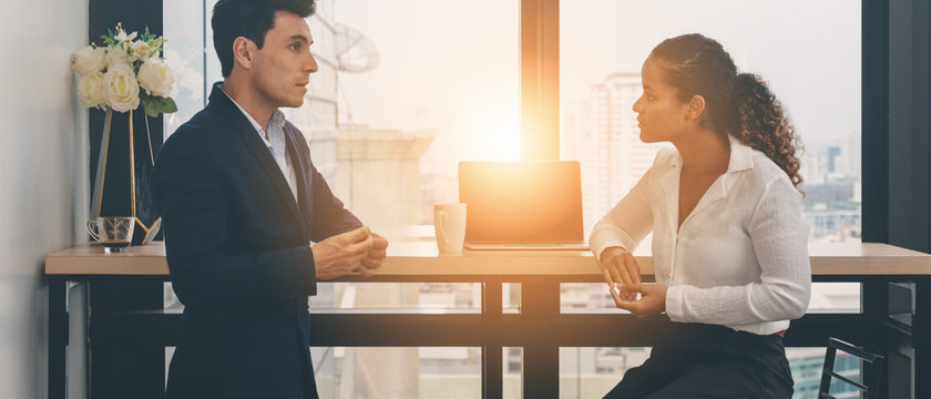 diverse business people having business conversation during coffee break time with laptop computer and cup of coffee at window corner in office