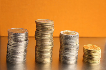 Euro metal coins are stacked on yellow background, financial concept, close-up, copy space