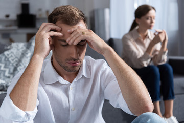 pensive upset couple in living room at home