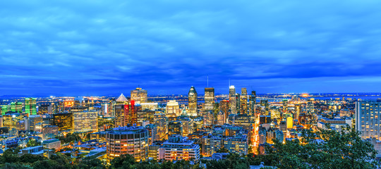 Top view of the Montreal city at sunrise or sunset, with illuminated buildings. Beautiful downtown skyscrapers and city skyline at night. Amazing panorama picture with Canadian town at autumn.