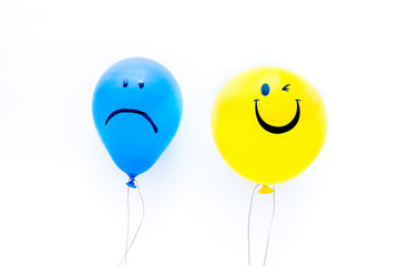 Treat depression concept. Balloons with sad and smiling faces on white background top view