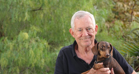 Senior man holding his dachshund