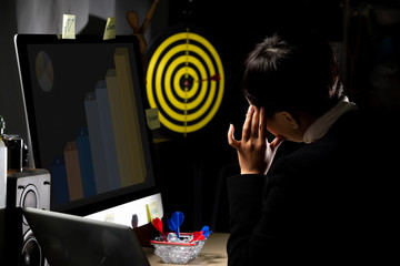 Tomboy Manager CEO looks at Dartboard and hold dart to throw as it is Growth of Business to achieve...