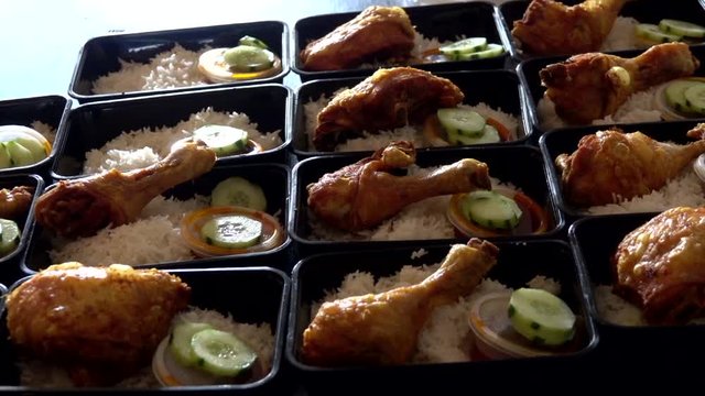A row of Nasi Lemak with Chicken Roasted in lunch boxes container for selling purpose in London street market.