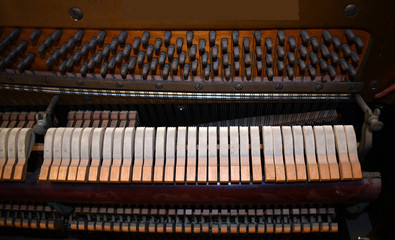 CLOSE UP Detail of dusty hammers striking string inside the old destroyed piano