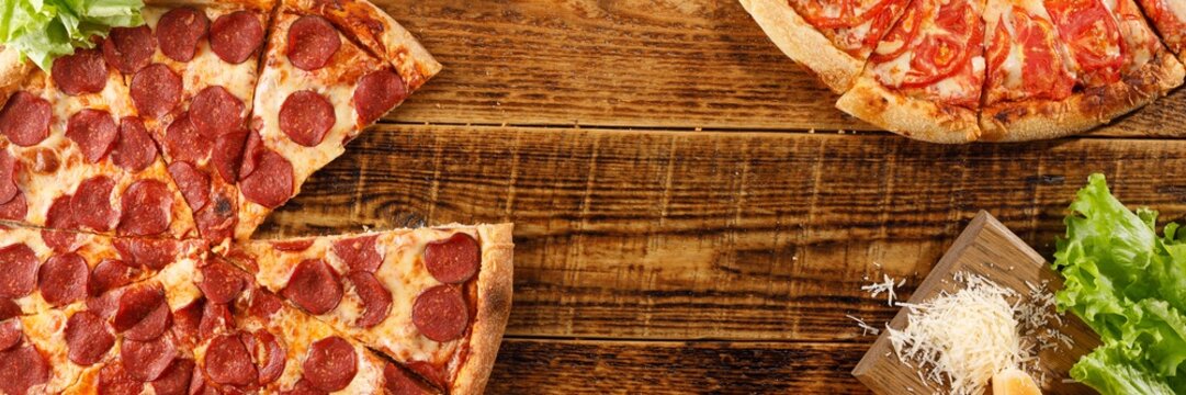 Pizza Pepperoni and Margarita on a wooden table. Still life with ingredients. Top view. Copy space.