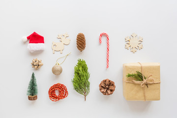 Christmas composition. Wrapped gift, wooden toys, lollipop cane on white. new year concept. Greeting card, winter holidays, xmas celebration 2020. Flat lay, top view, copy space, mockup, template